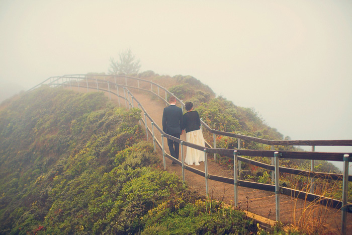 bride and groom walking along wooden path