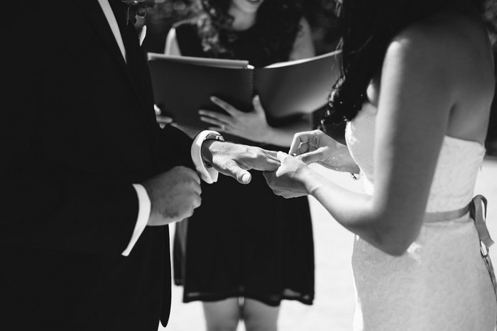 bride putting ring on groom's finger