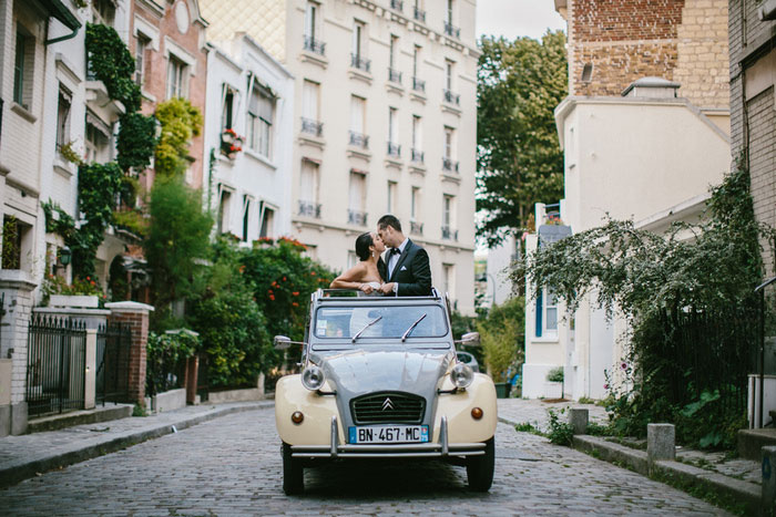 bride and groom kissing while standing in VW bug