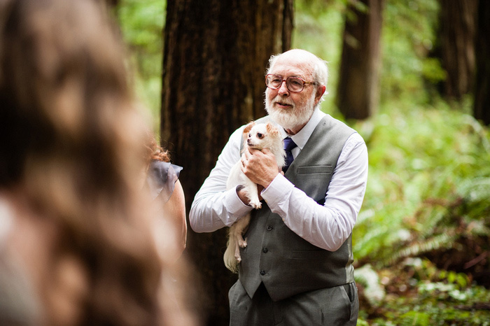 father of the bride holding chihuahua during ceremony