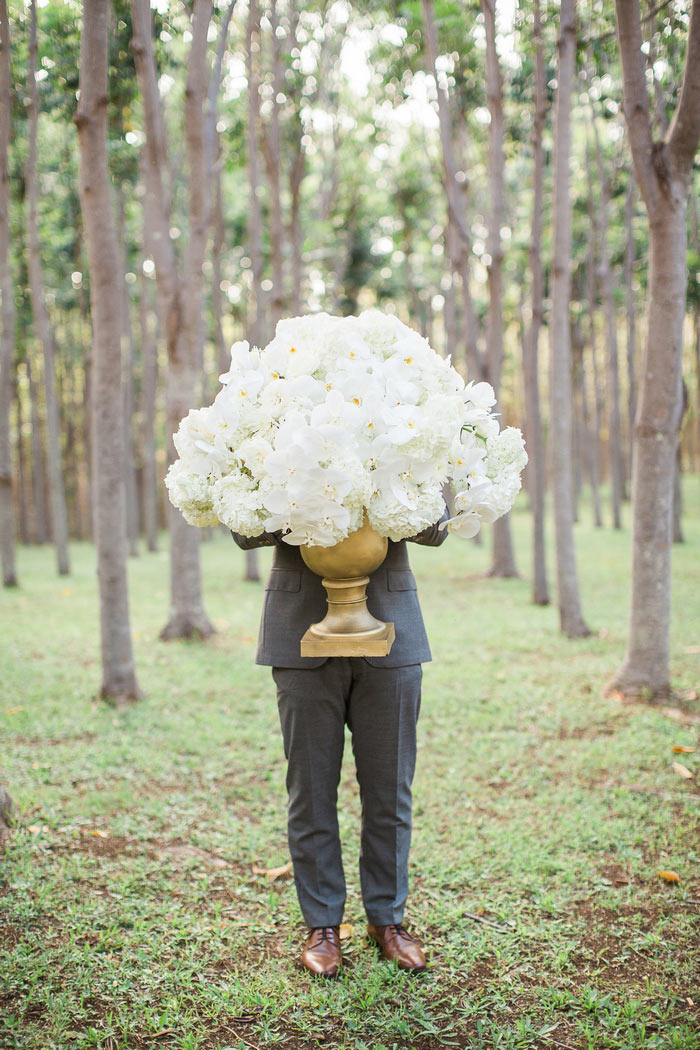 groom holding huge floral arrangement
